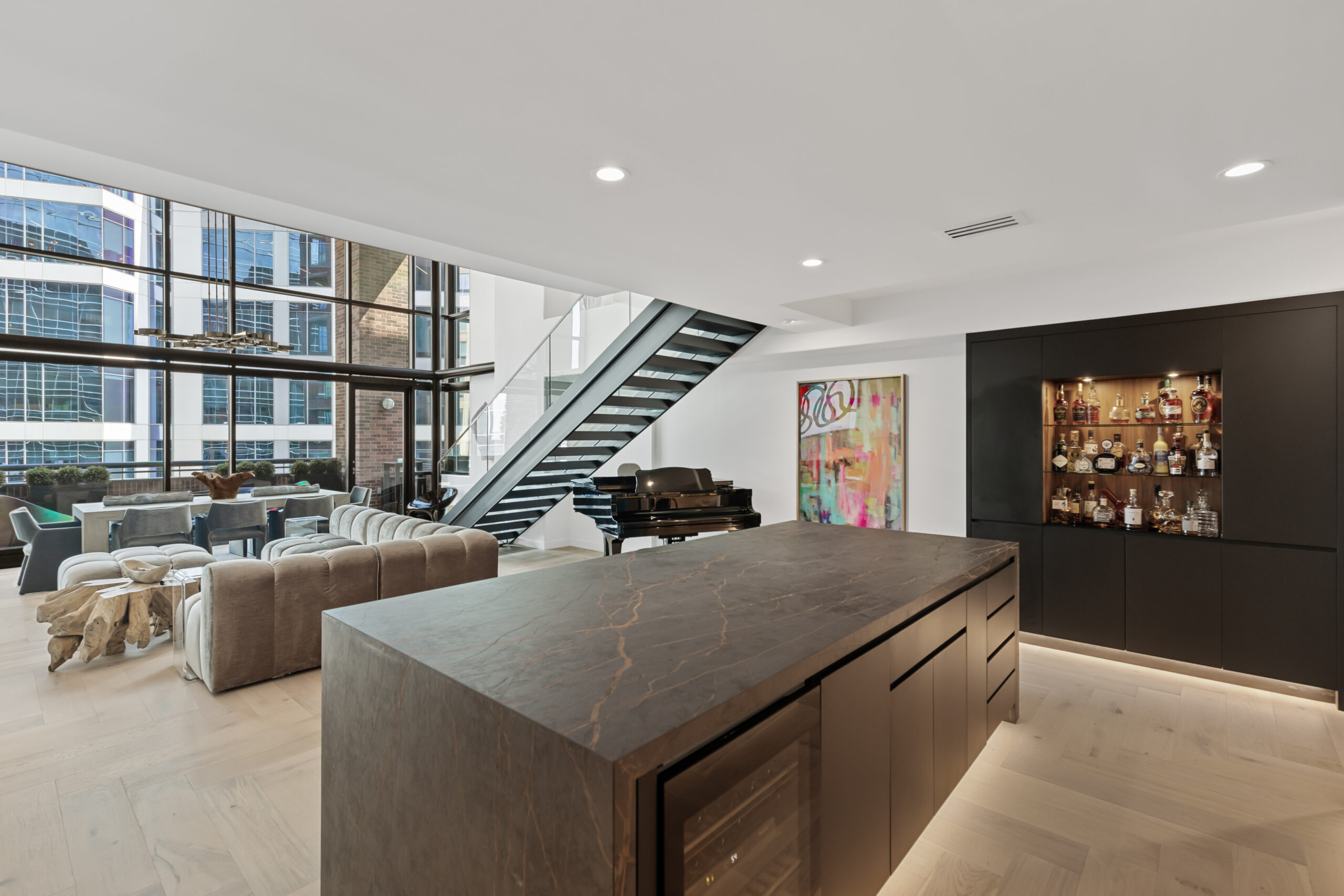 Sleek no-hardware kitchen cabinets in a luxury high-rise condo by StyleCraft Cabinets Dallas.