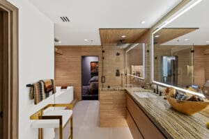 Floating master bathroom vanity with natural stone top by StyleCraft Cabinets, Texas.