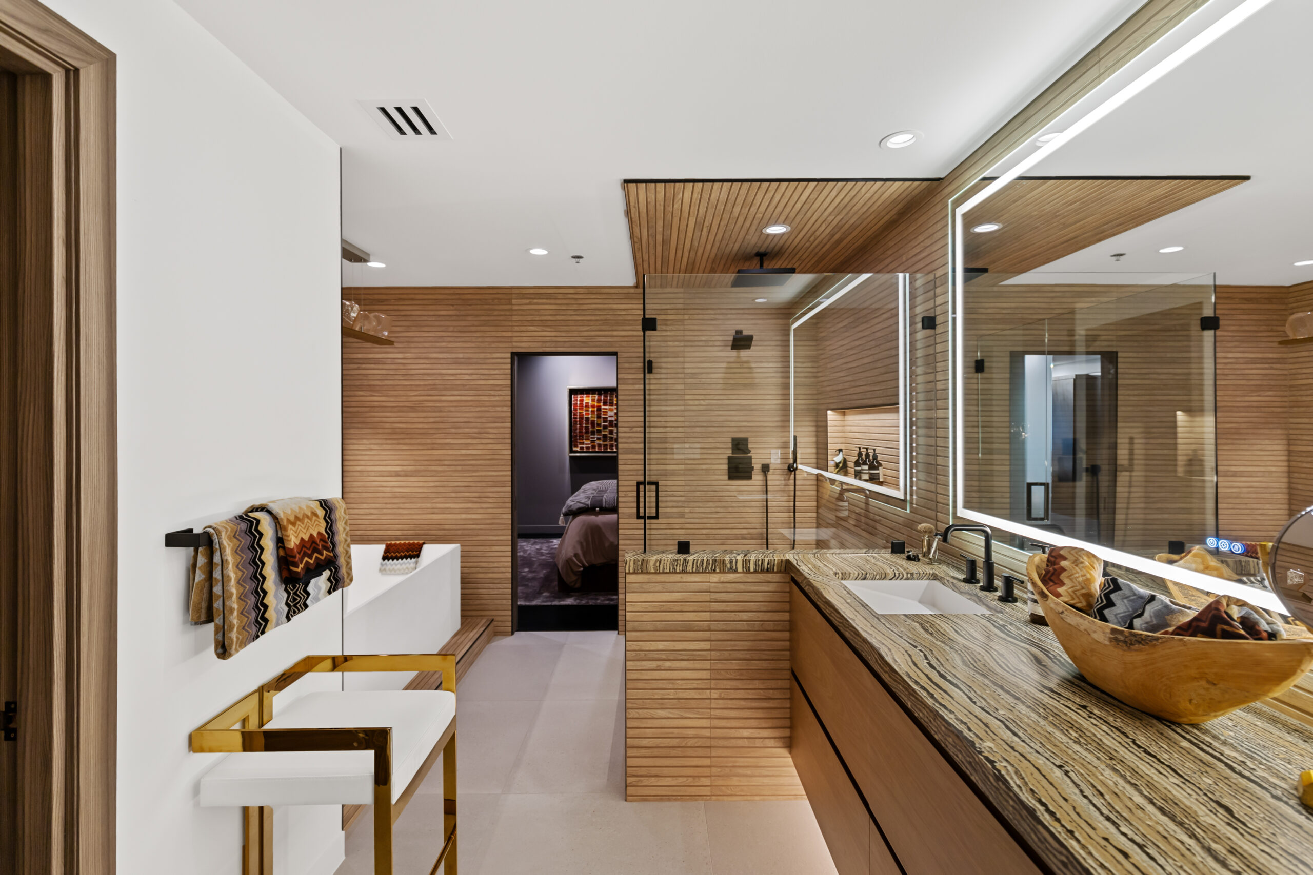 Floating master bathroom vanity with natural stone top by StyleCraft Cabinets, Texas.
